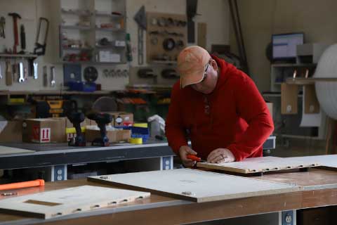 Carpenter measuring wood in workshop